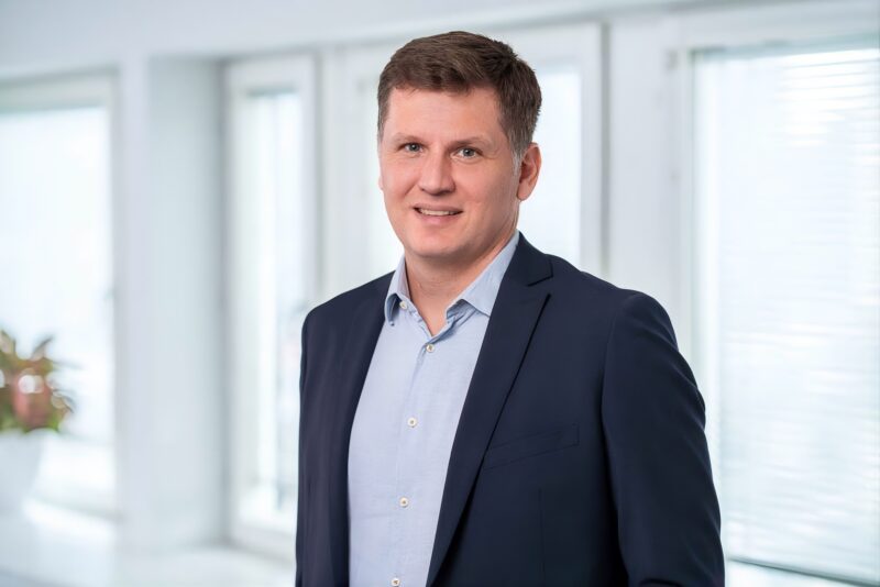 Lyhyttukkainen mies sinisessä puvussa.